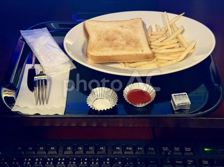 ネットカフェの朝食　トーストとポテト ブルーライト,ネットカフェ,暗がりの写真素材