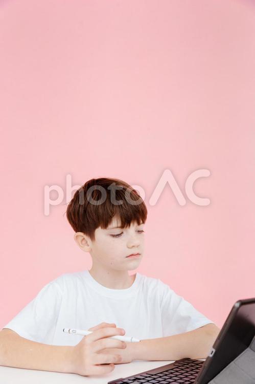 ペンを持ち勉強中の男の子 男の子,ノートパソコン,見るの写真素材