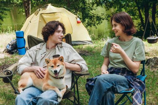 芝生に座り犬を抱く女性 男女,外国人,犬の写真素材