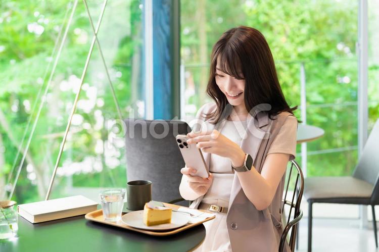 カフェでケーキの写真を撮影する女性 女性,カフェ,写真の写真素材