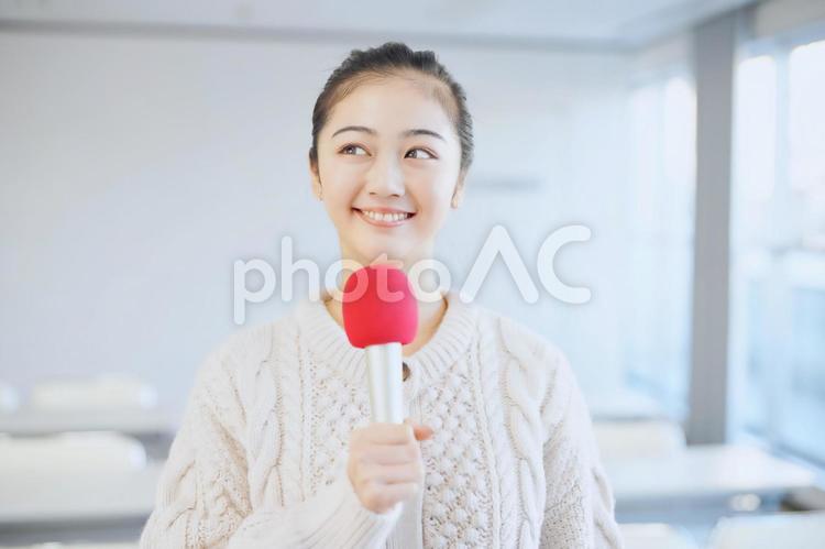 マイクを持って考える女性 女性,大学生,マイクの写真素材