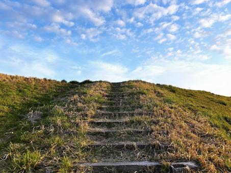 土手に伸びる階段の写真