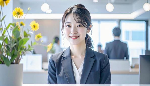 笑顔で対応する女性の受付嬢 笑顔で対応する女性の受付嬢の写真
