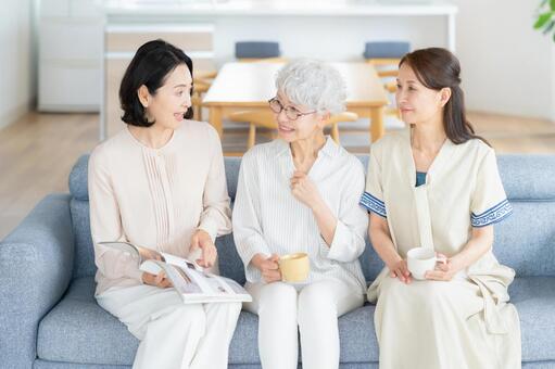 リビングで雑誌を見るシニアの女性と友達 女性,シニア,読書の写真素材