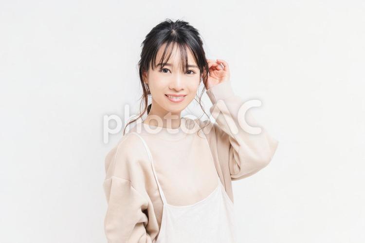 白い背景の前に立ってポーズをとる若い女性 女性,白背景,立つの写真素材