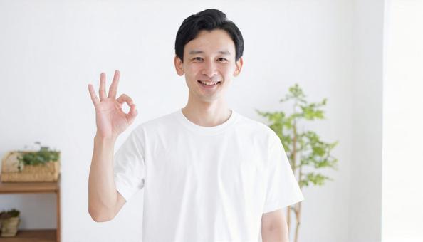 室内でOKサインをする笑顔の男性の写真