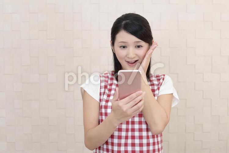 スマートフォンを持つ笑顔の女性 女性,主婦,女の写真素材