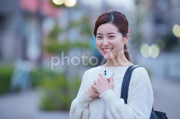 スマートフォンを持って笑顔な女性の上半身 女性,笑顔,にっこりの写真素材