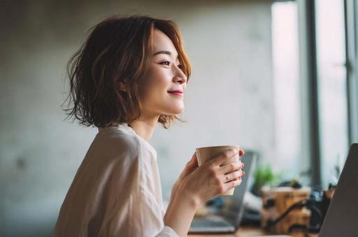 デスクで一息つくビジネス女性 デスクで一息つくビジネス女性の写真