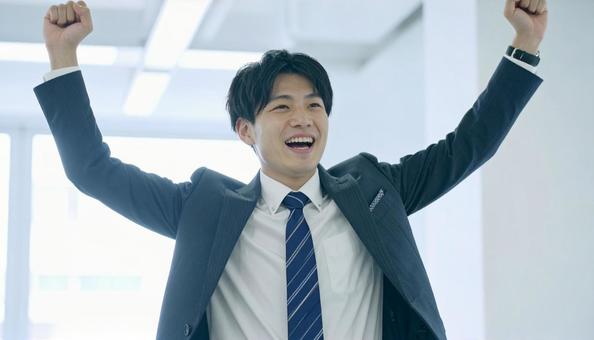 オフィスで喜ぶビジネスマン オフィスで喜ぶビジネスマンの写真