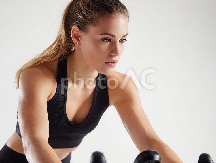 エアロバイクでトレーニングする若い女性 女性,若い,フィットネスの写真素材
