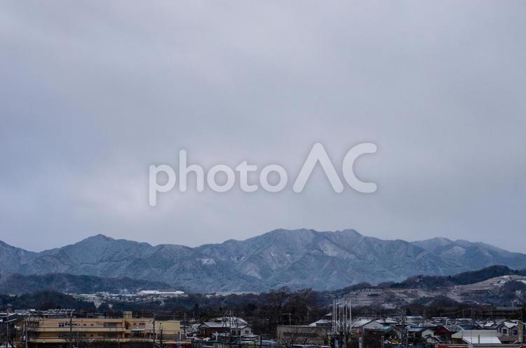 街の近くの雪をかぶった低い山 山,冬,雪山の写真素材