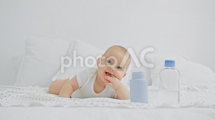 左手を口に入れ笑う赤ちゃん 赤ちゃん,かわいい,指しゃぶりの写真素材