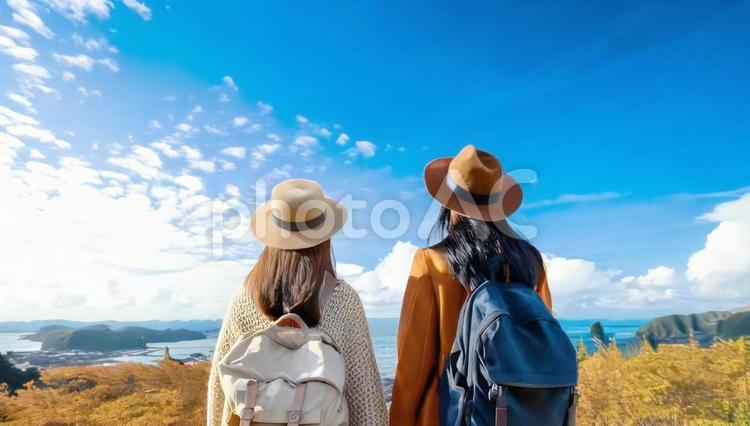 青空と海に向かって立つ2人の女性の後姿 女性,人,2人の写真素材