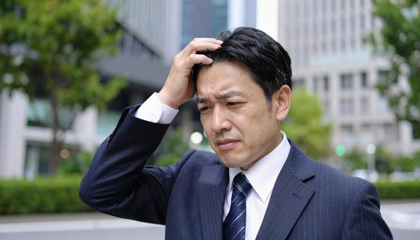 うっかりミスをして頭を抱えるビジネスマン うっかりミスをして頭を抱えるビジネスマンの写真
