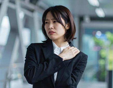 辛い肩凝りで苦しむ女性 辛い肩凝りで苦しむ女性の写真