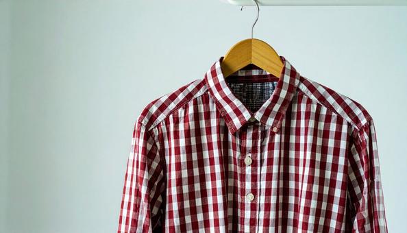 ハンガーにかかる赤ストライプのネルシャツの写真