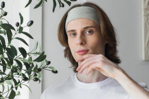 顎を触っているヘアバンドをしたカメラ目線の男性 男性,外国人,欧米人の写真素材