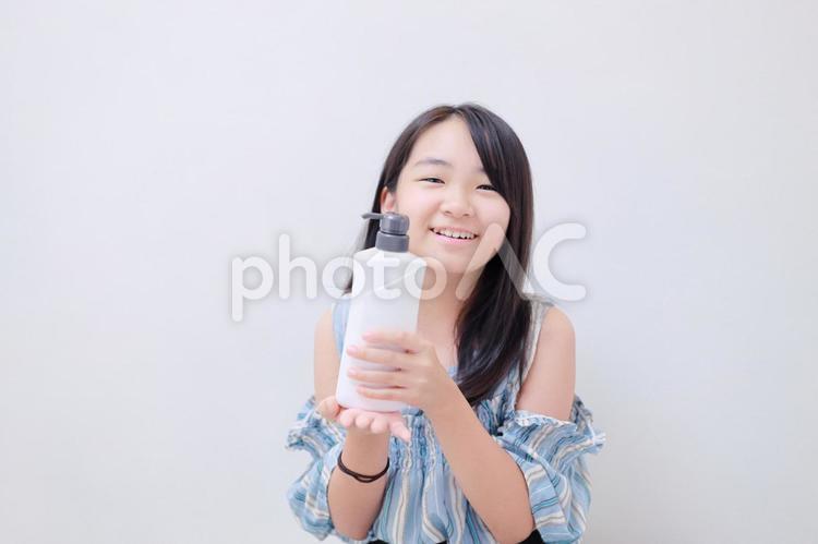 白色のシャンプーボトルを持った笑顔の少女 女性,日本人,若いの写真素材
