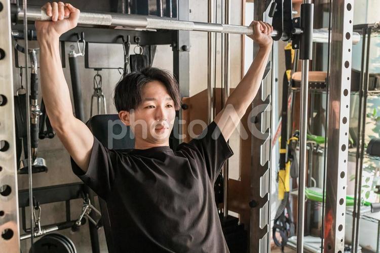 ジムでショルダープレスマシンを使う男性 ショルダープレス,スポーツジム,筋トレの写真素材