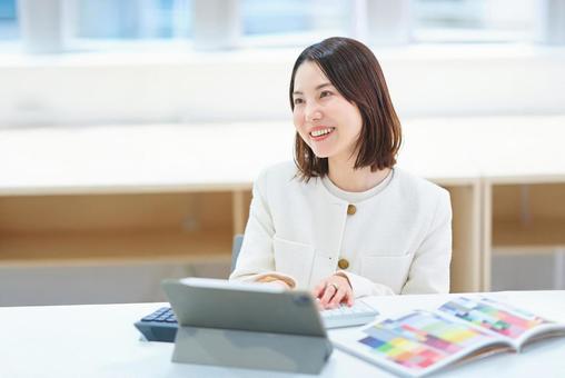 室内で仕事をするスーツ姿の女性 室内で仕事をするスーツ姿の女性 パソコン,タブレットpc,女性の写真素材