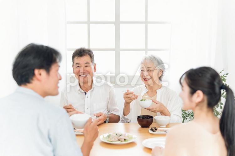 楽しい食事をする老夫婦と若い夫婦（笑顔） 家族,食事,里帰りの写真素材