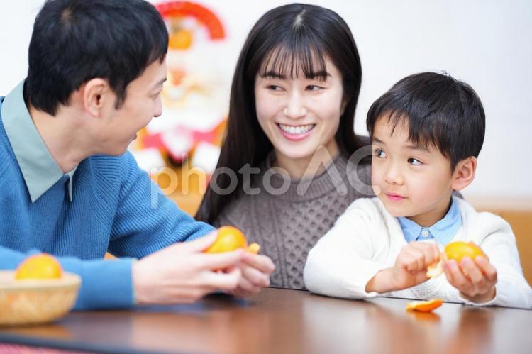 みかんの皮を剥きながら話す家族 家族,女性,男性の写真素材