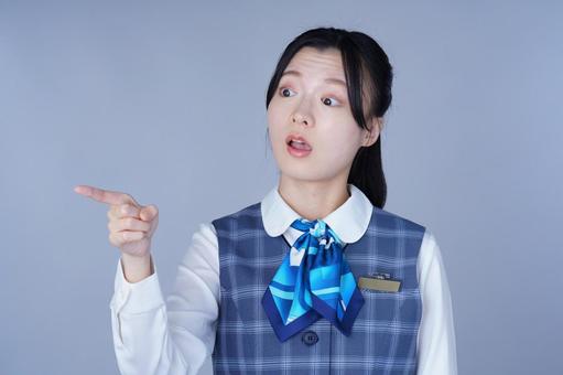 青いリボンの制服の女性が驚く 女性,指差し,ポーズの写真素材
