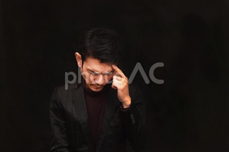 うつむいて悩む男性 悩む,考える,悩みの写真素材