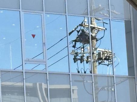ビル・反射する電柱の写真