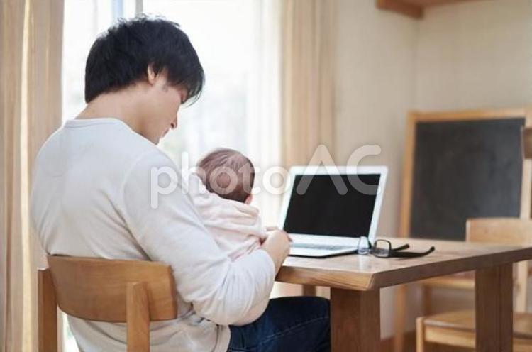 赤ちゃんの子守りをしながら仕事をするパパ 赤ちゃん,子守り,仕事の写真素材
