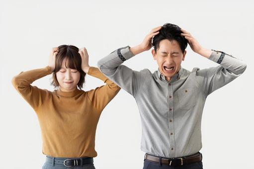 頭を抱えて悩む男女2人のビジネスマン 頭を抱えて悩む男女2人のビジネスマン 男性,女性,男女の写真素材