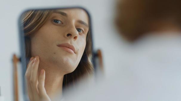 顎を触っている鏡越しの男性 男性,外国人,欧米人の写真素材