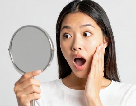 鏡を見て驚く女性のリアクション 鏡を見て驚く女性のリアクションの写真
