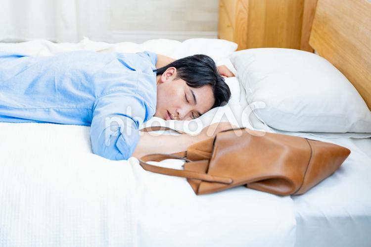 ベッドに倒れる私服の男性 睡眠,過労,倒れるの写真素材