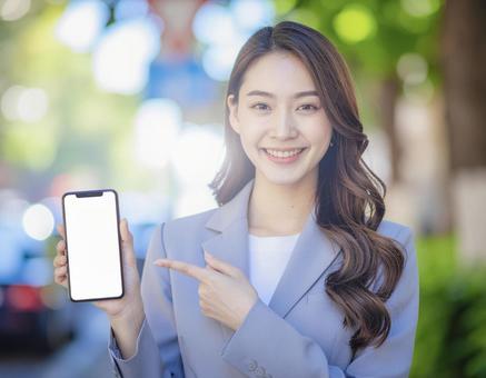 スマホを持つ笑顔の女性4 スマホを持つ笑顔の女性4の写真