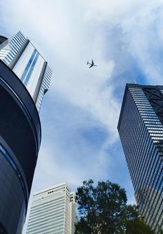 「都会の空」飛行機と下から見上げたビル群 「都会の空」飛行機と下から見上げたビル群 飛行機,空,都会の写真素材