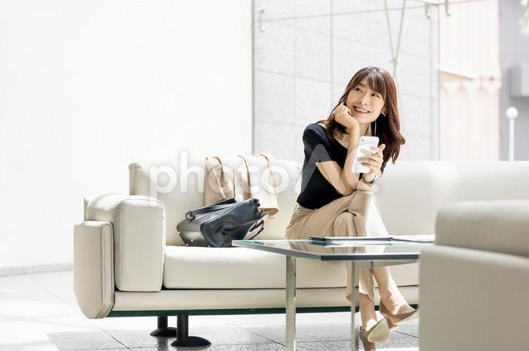 ソファでスマホを使うビジネスウーマン 女性,ビジネス,スマホの写真素材