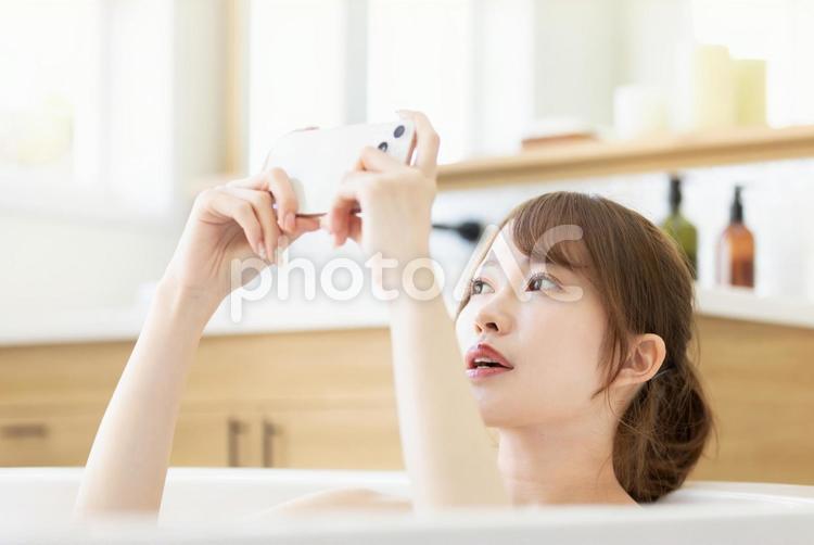 お風呂でスマートフォンを使う女性 女性,人物,スマートフォンの写真素材