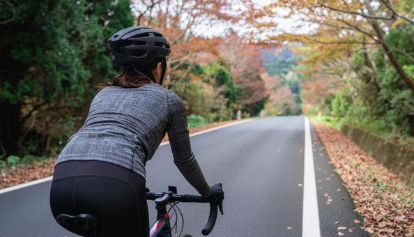 ロードバイクでサイクリングする女性 ロードバイクでサイクリングする女性の写真