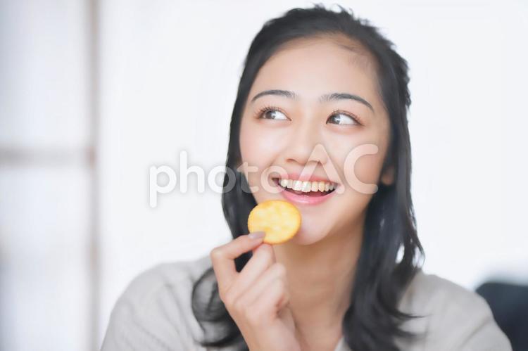 お菓子を持ち横を見る女性 女性,横を見る,お菓子の写真素材
