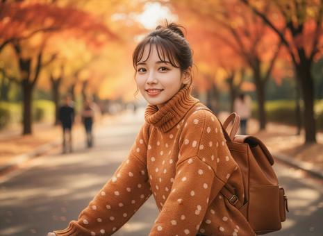 秋の紅葉を背景に自転車にのる女性 秋の紅葉を背景に自転車にのる女性の写真