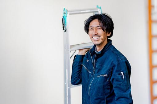 脚立を持って笑う電気工事士 工事,電気,仕事の写真素材