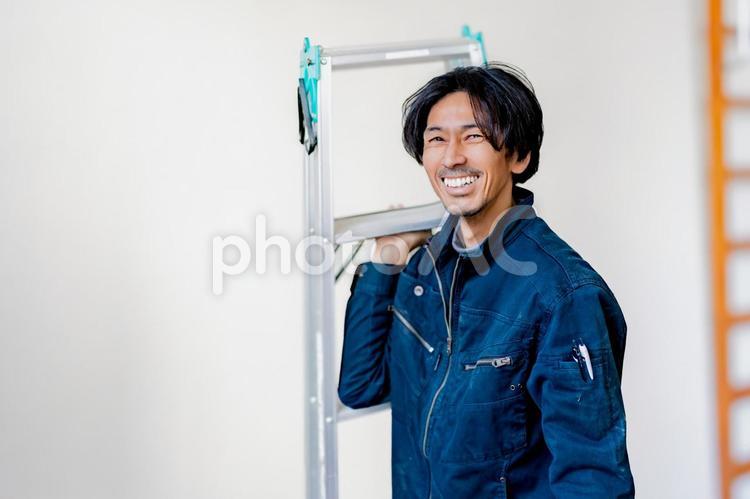 脚立を持って笑う電気工事士 工事,電気,仕事の写真素材