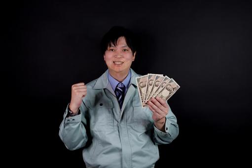 お金を持つ作業服の男性 お金を持つ作業服の男性 男性,作業服,お金の写真素材