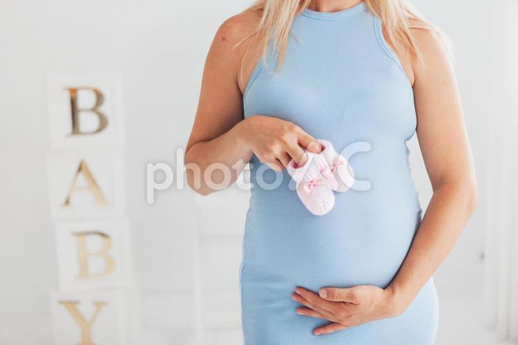 ベビーシューズを持っている妊婦さんの手元 手元,女性,人物の写真素材