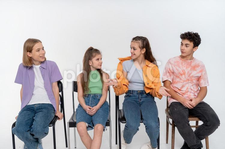 椅子に座って話しをしている4人のティーンエイジャーの男女（白背景） ティーンエイジャー,男の子,女の子の写真素材
