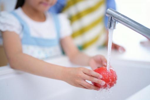 流し台で野菜を丁寧に洗う手のアップ トマト,水道,蛇口の写真素材