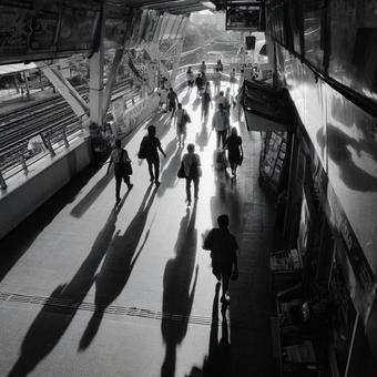 夕暮れに長い影を落とす都市の歩行者 夕暮れに長い影を落とす都市の歩行者の写真