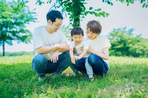 Parents and children sitting on a sunny green space, JPG Parents and children sitting on a sunny green space, JPG